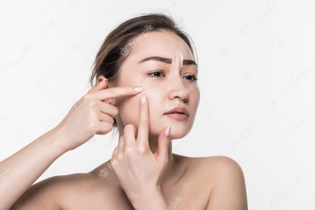 portrait-young-attractive-woman-touching-her-face-looking-acne-isolated-white-wall_231208-1025
